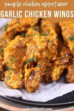 chicken wings with sauce and parsley on top in a black plate, text overlay reads simple chicken appetizer garlic chicken wings