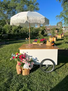 an umbrella and flower arrangement on display in the grass with a bike parked next to it