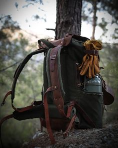 a backpack sitting on the ground next to a tree