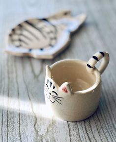 two ceramic cats sitting next to each other on a table