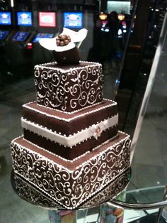 a three tiered cake sitting on top of a glass table