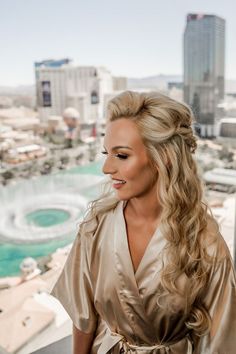 a woman standing on top of a building next to a cityscape with buildings in the background