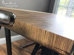 a close up of a wooden table with metal legs