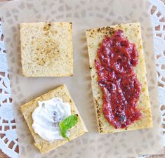 crackers with spread on them sitting on a doily