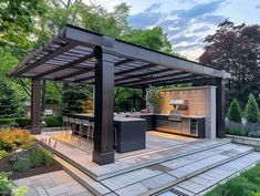 an outdoor kitchen and dining area in a backyard