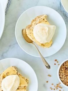 three white plates topped with desserts on top of a marble counter next to silverware