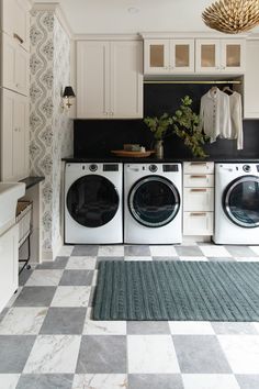 a white and black checkered kitchen with washer and dryer in the middle