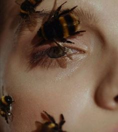 a woman's eyes with bees on them