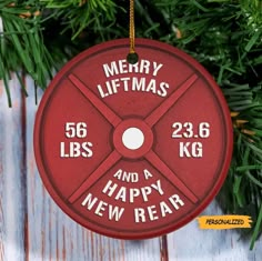 a red ornament hanging from a christmas tree with the words merry liftmas and a happy new year written on it