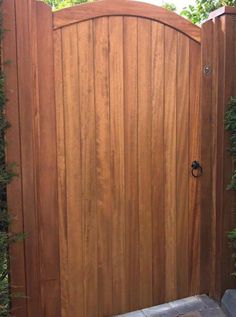 a wooden gate in the middle of a garden