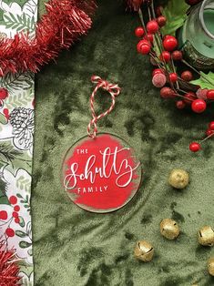 a christmas ornament with the words santa's family on it and ornaments around it