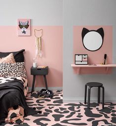 a bedroom with pink and grey walls, leopard print bedding and black accents on the floor