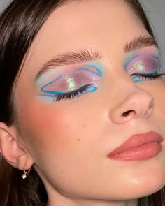 a woman with blue and pink eye makeup