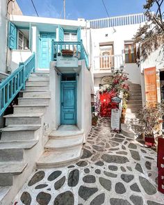 a blue door is on the side of a white building with steps leading up to it