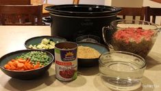 the food is prepared and ready to be cooked in the crock pot, rice, peas, carrots, potatoes, and other ingredients