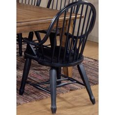 a dining room table and chairs with a rug on the floor in front of it