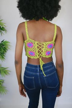 This crochet top is an ultra breezy and edgy style option. She is dyno-mite with a halter swim top or bralette. But for my free spirited sister, you can wear her as is to a festival or beach party. She's a retro green and with pink crochet flowers. She features a corset style back so that you can cater her to your own custom fit! Style Tip: Use as a swim stop cover or style with ribbed denim shorts for a easy casual look Made of Acrylic Trendy Stretch Crochet Top For Beach, Trendy Crochet Top For Beach In Spring, Trendy Crochet Top For Beach Season Vacation, Spring Beach Tank Top With Crochet Trim, Green Summer Crochet Top With Crochet Trim, Trendy Crochet Beach Top For Summer, Green Crochet Trim Summer Top, Trendy Summer Crochet Top For Beach, Fitted Crochet Top For Spring With Beachy Style