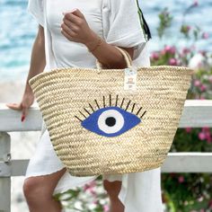 Introducing the Straw Evil Eye Large Bag: Your Perfect Summer Companion Embrace the spirit of summer with our stunning Straw Evil Eye Large Bag. This handcrafted accessory combines traditional craftsmanship with trendy design, making it the ideal choice for beach outings, picnics, or casual city strolls. Exquisite Handmade Craftsmanship Each Straw Evil Eye Large Bag is meticulously handcrafted by skilled artisans, ensuring that every piece is unique and of the highest quality. The natural straw Summer Beach Shoulder Bag Made From Palm Leaf, Handmade Beach Bag For Travel During Beach Season, Bohemian Summer Bags In Natural Color, Bohemian Style Natural Color Summer Bags, Palm Leaf Bag For Beach Season Market, Summer Beach Bag Gift, Palm Leaf Bag For Beach Season And Market, Summer Palm Leaf Bag For Market, Natural Color Beach Season Bags For Gift