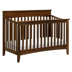 a wooden crib with white sheets on the bottom and side rails, against a white background