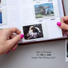 two hands holding an open photo book with photos on the pages and in between them