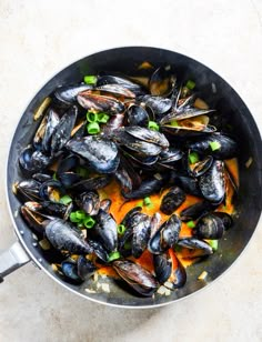 a pan filled with mussels on top of a table