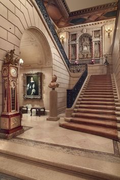 an ornate staircase leading up to a painting on the wall