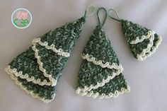 three crocheted christmas trees hanging from strings