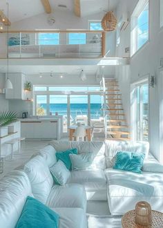 a living room filled with white furniture and lots of windows next to the ocean in front of it