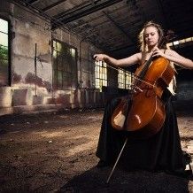 a woman is playing the cello in an old building