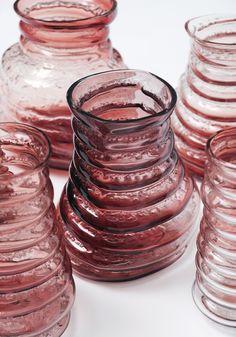 several pink glass vases stacked on top of each other