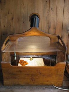 a wooden box with an open lid on top of it, sitting next to a wood paneled wall