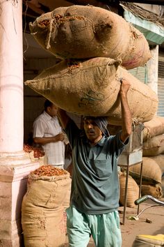 a man carrying large bags on top of his head