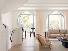 a living room filled with furniture and large windows