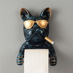 a statue of a dog with goggles on it's head holding a roll of toilet paper