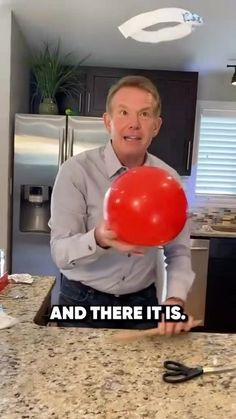 a man holding a red ballon in his hand with the caption and there it is