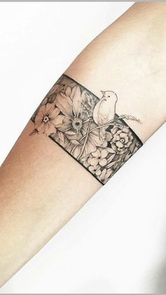 a woman's arm with flowers and a bird on it