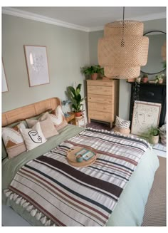 a bed room with a neatly made bed and some pictures on the wall above it