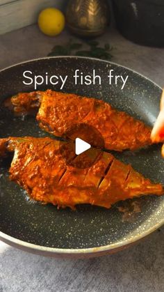 two pieces of fish being cooked in a frying pan with the words spicy fish fry on it