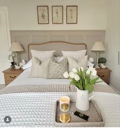 a tray with flowers and candles on a bed