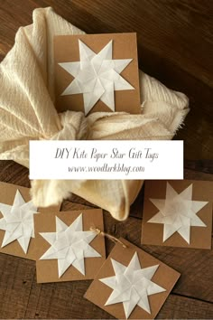 paper star gift tags on top of a wooden table with some folded ones next to them