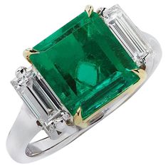 an emerald and diamond ring with two baguets