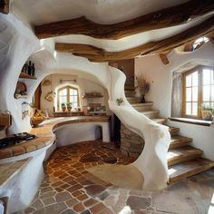 the interior of an unusual house with stone floors and steps leading up to it's kitchen