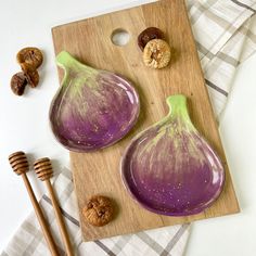 two figs on a cutting board next to some nuts