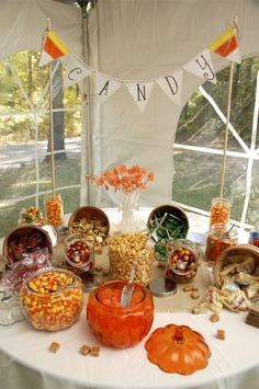 a table filled with candy and candies on top of a white cloth covered table