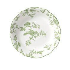 a green and white plate with flowers on the rim, in front of a white background