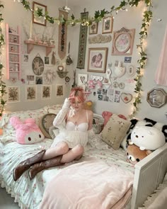 a woman sitting on top of a bed in a room filled with pictures and stuffed animals