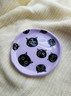 a purple plate with black cats on it