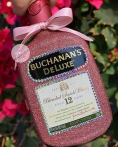 a bottle of champagne with a pink bow on it's neck and label that says buchannan's deluxe