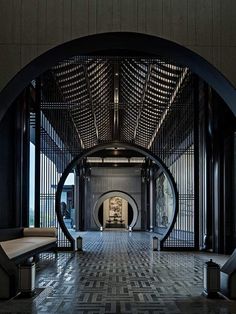 the inside of a building with an arched doorway and tiled floor, along with benches