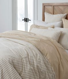 a bed with beige and white striped comforters